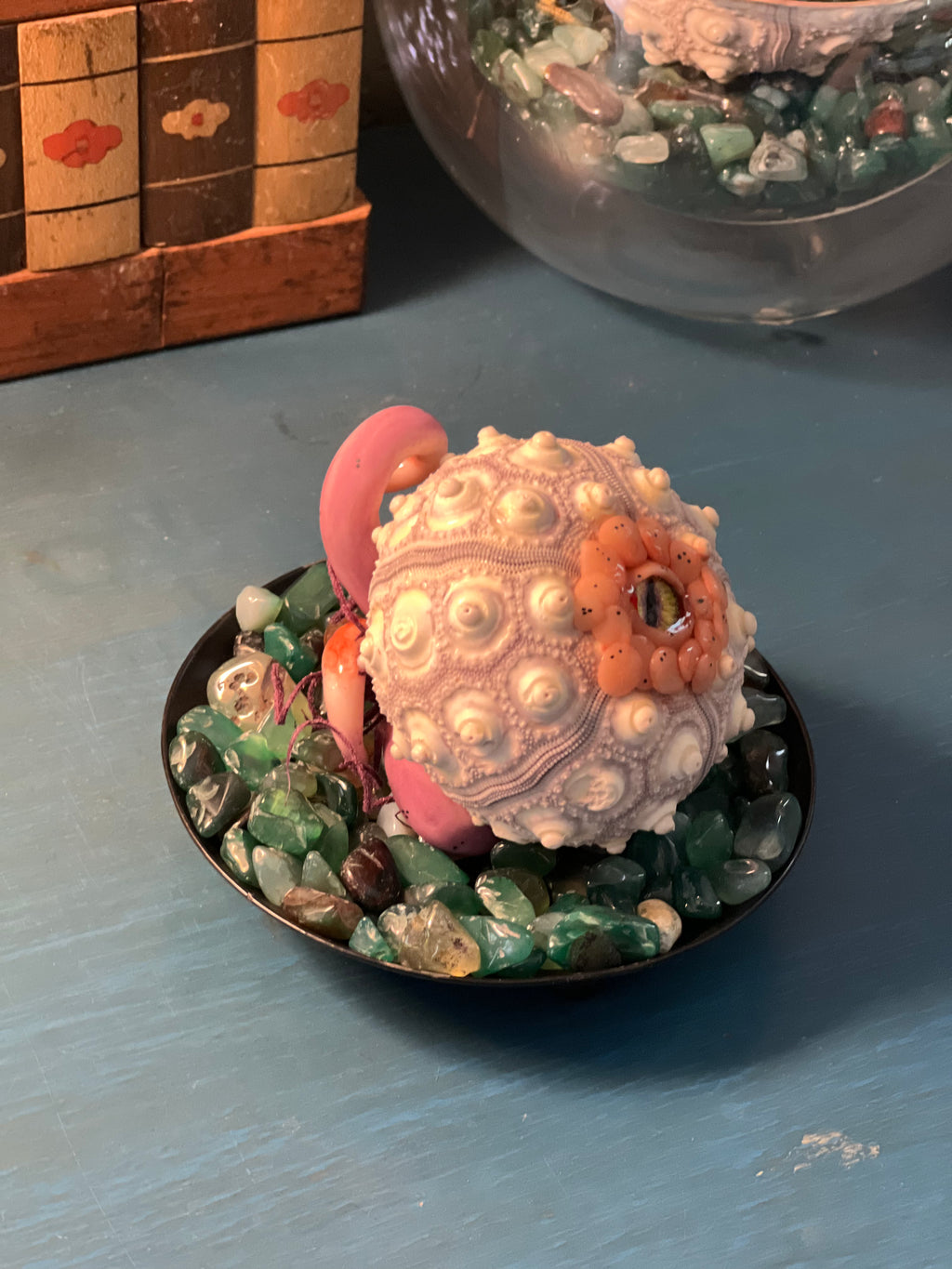 Hand sculpted from polymer clay and nestled inside a natural sea urchin skeleton, every hatchling possesses its own unique personality and expression.