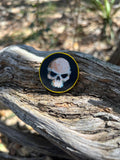 Handpainted Wooden Coin Token with a skull on the heads side and hip bones on the tails side.
