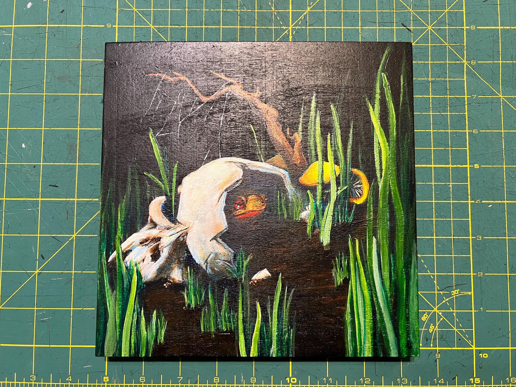 Painting of a toad hiding in a broken skull