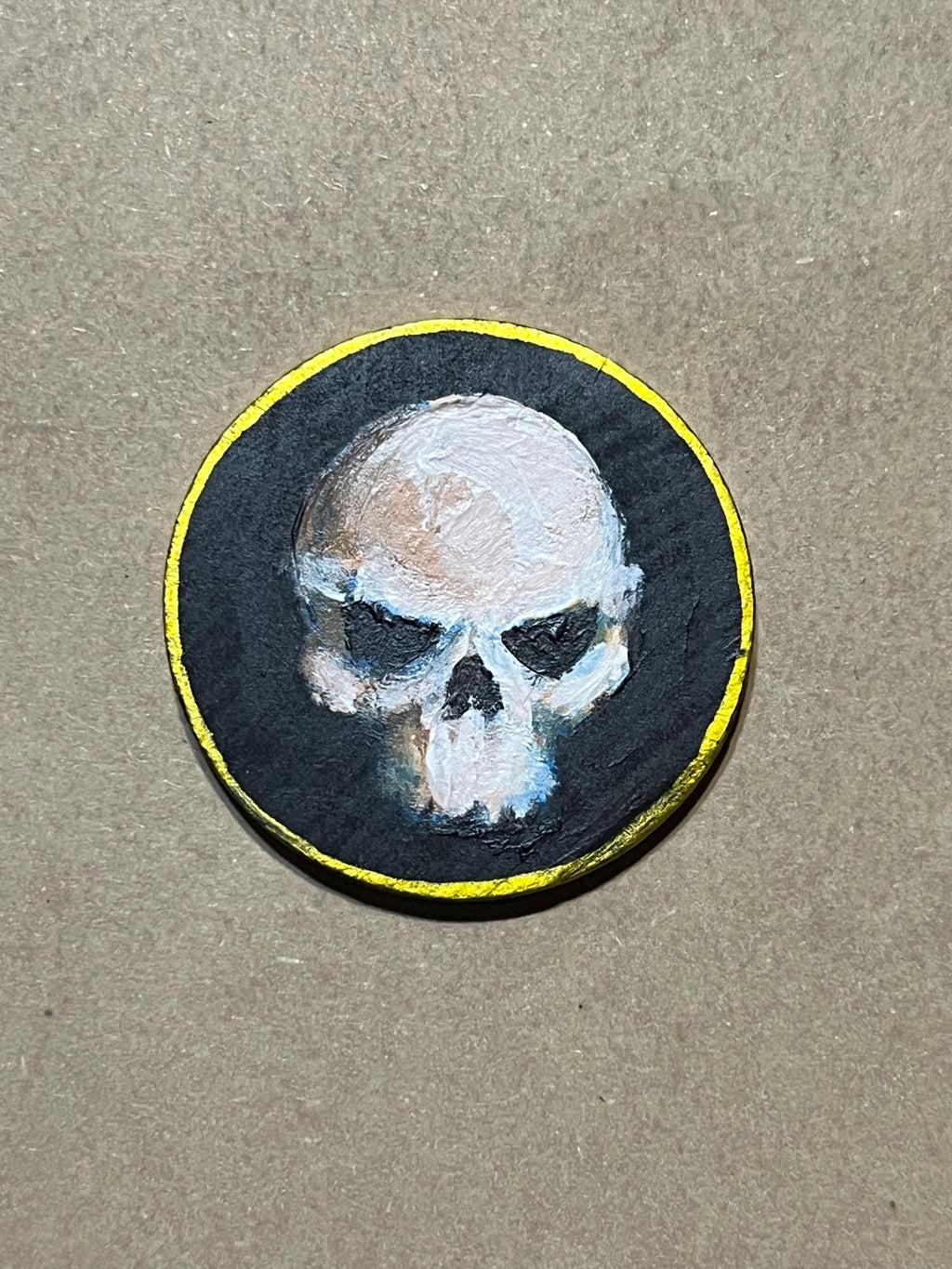 Handpainted Wooden Coin Token with a skull on the heads side and hip bones on the tails side.